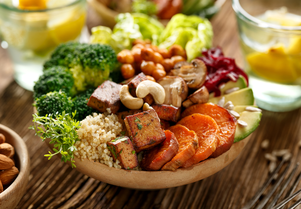 vegan buddha bowl, containing sweet potato, couscous, broccoli and other vegetables loading=